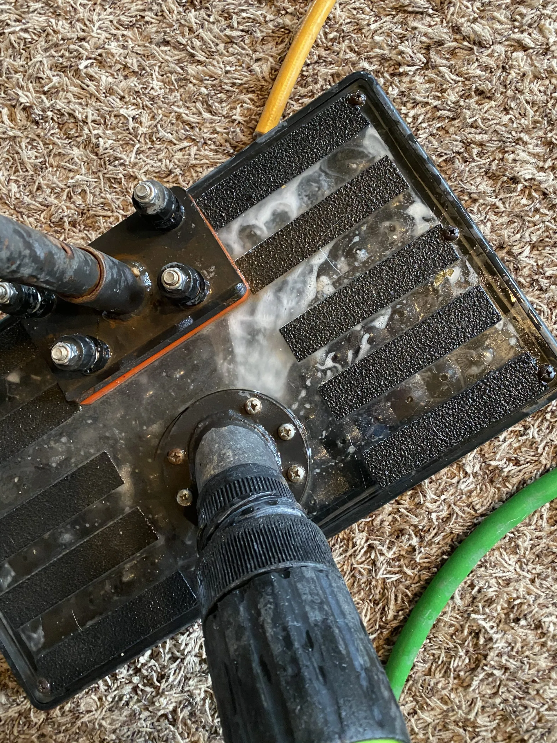 Professional technician using a truck-mounted steam cleaning system and wand to clean carpets with precision.